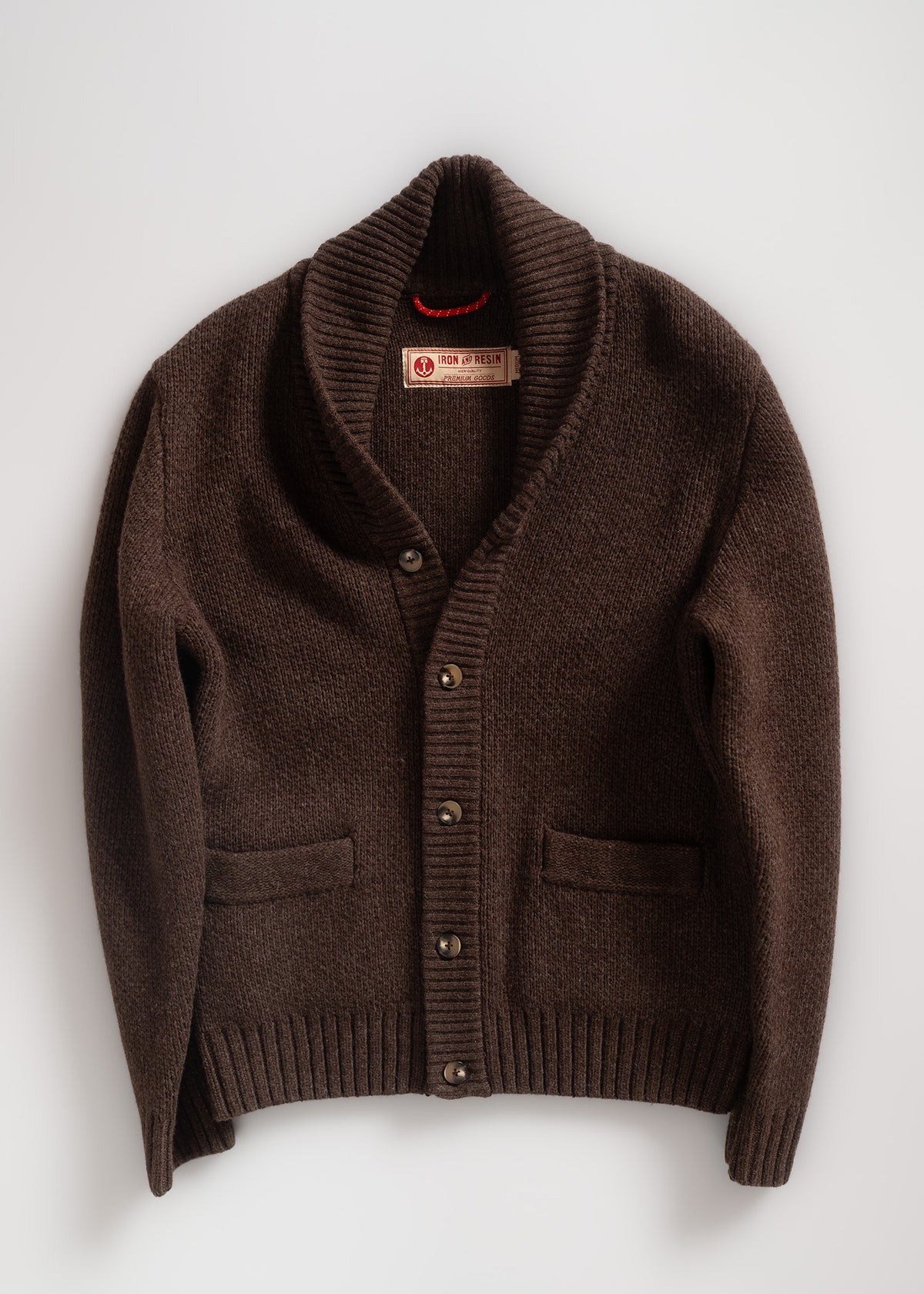 Brown cardigan with shawl collar and buttons, featuring Iron & Resin label. Cozy knit texture, laid flat on a white background.
