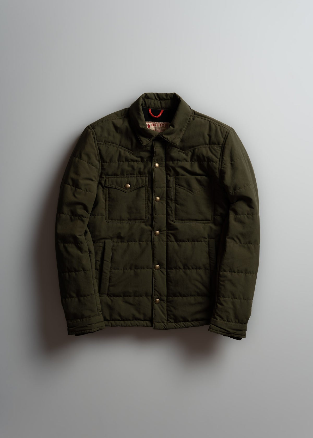 Olive green quilted jacket with button closure and two chest pockets, displayed against a plain background.