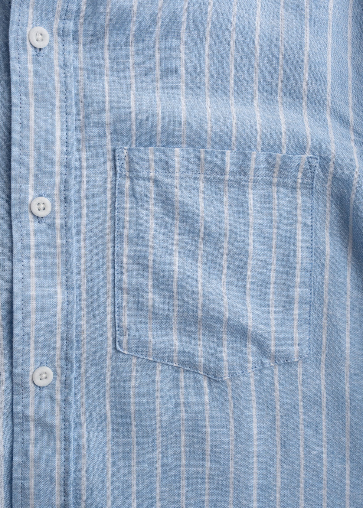 Close up of single chest pocket on shirt, showcasing stitching and minimal utility design