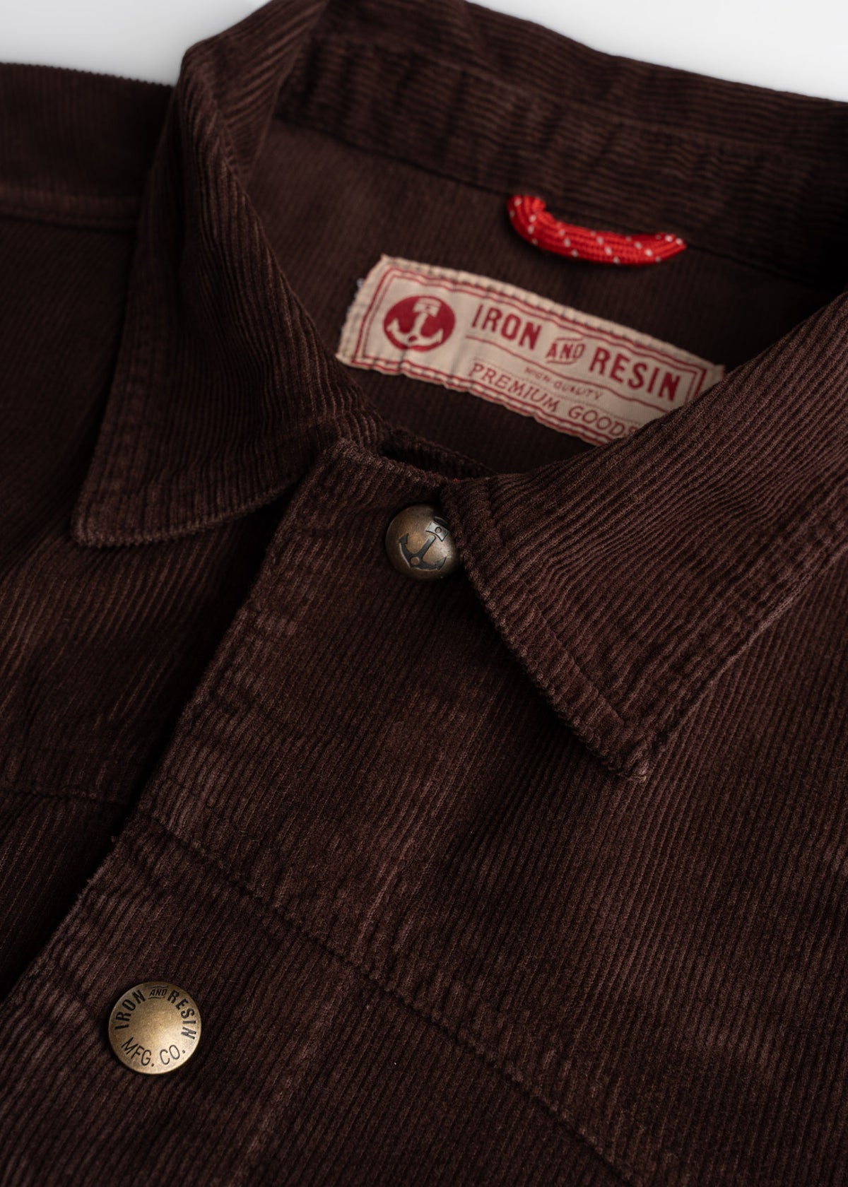 Close up of neck, custom buttons and interior locker loop cord, showcasing practical hanging detail and workwear function