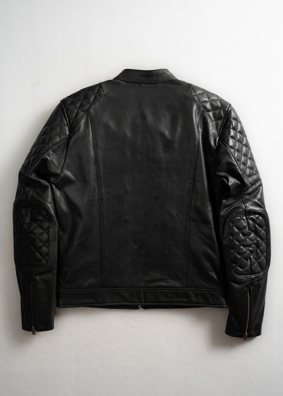 Black leather jacket with quilted shoulders and elbows, viewed from the back against a plain background.