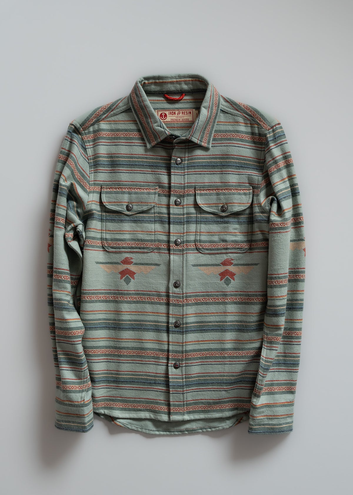 Striped button-up shirt with geometric patterns, two chest pockets, and a collar, displayed against a plain background.