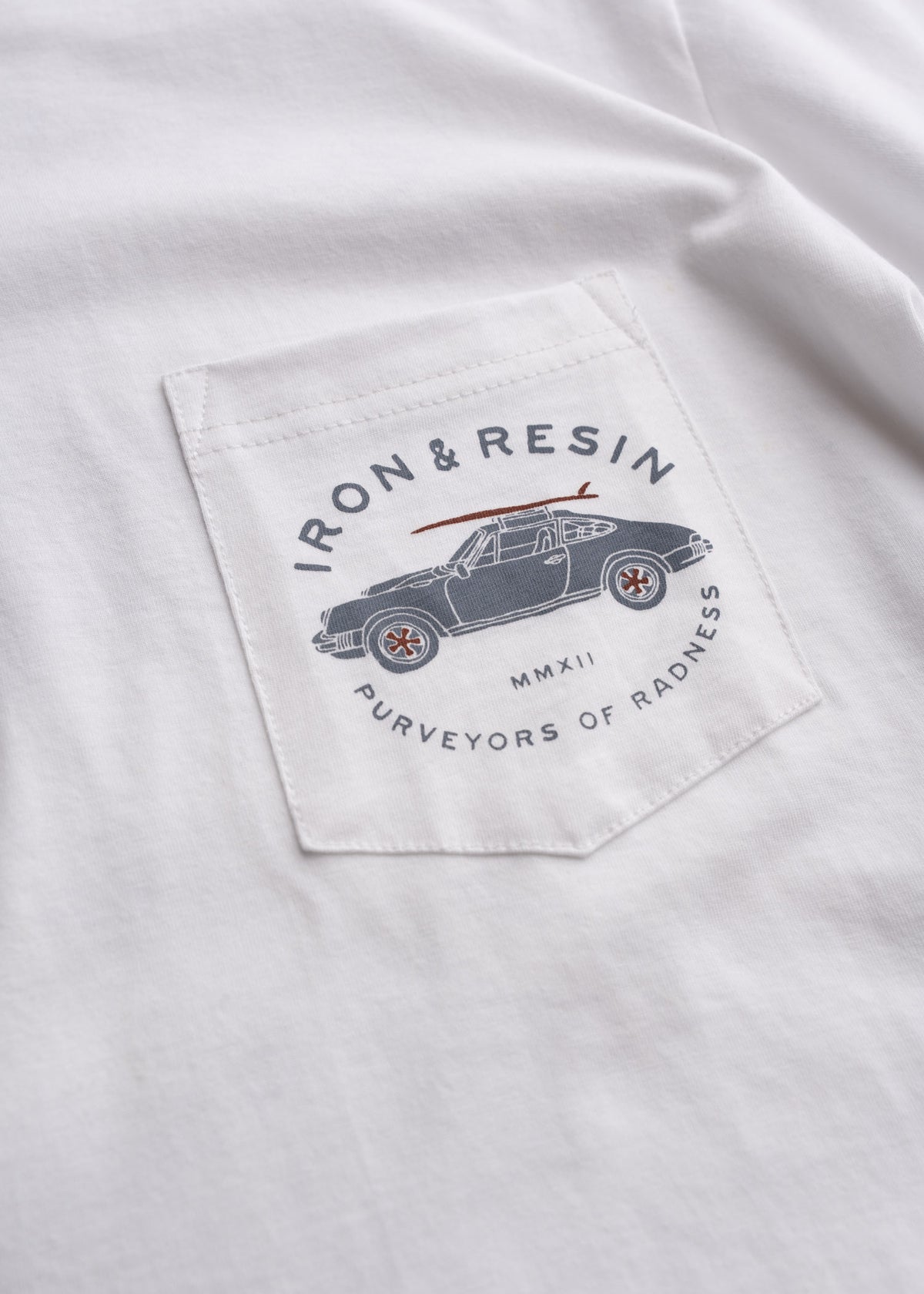 White shirt with "Iron & Resin" logo on pocket, featuring a vintage car design and "Purveyors of Radness" text.