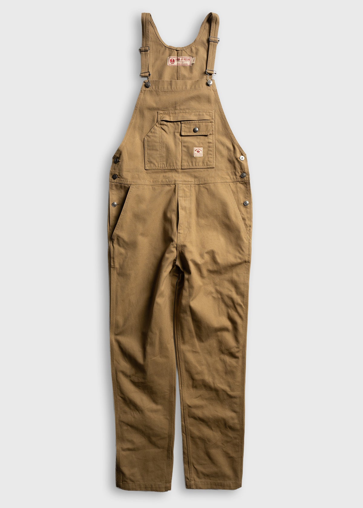 Brown work overalls with adjustable straps and front pocket, displayed on a white background. Durable and practical design.