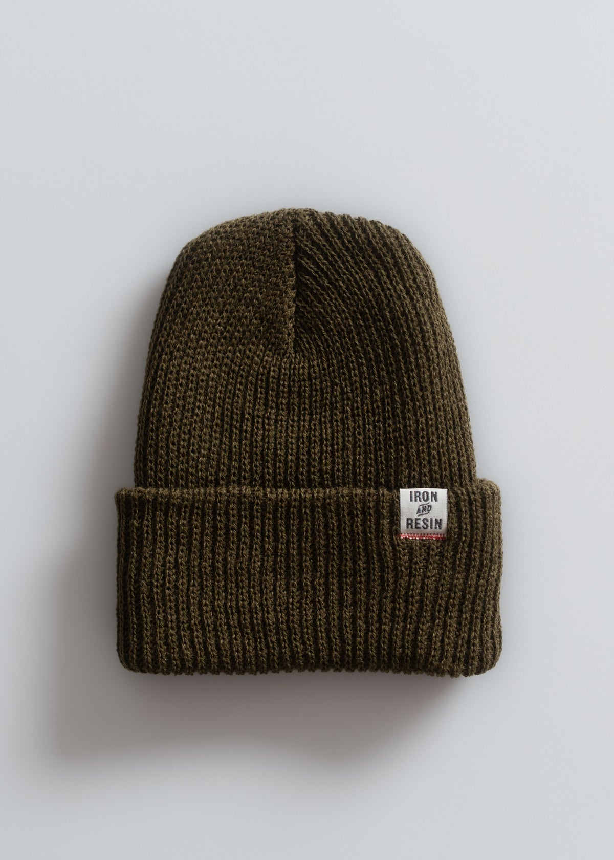 A brown knit beanie with a folded brim and an "Iron and Resin" label, displayed against a plain white background.