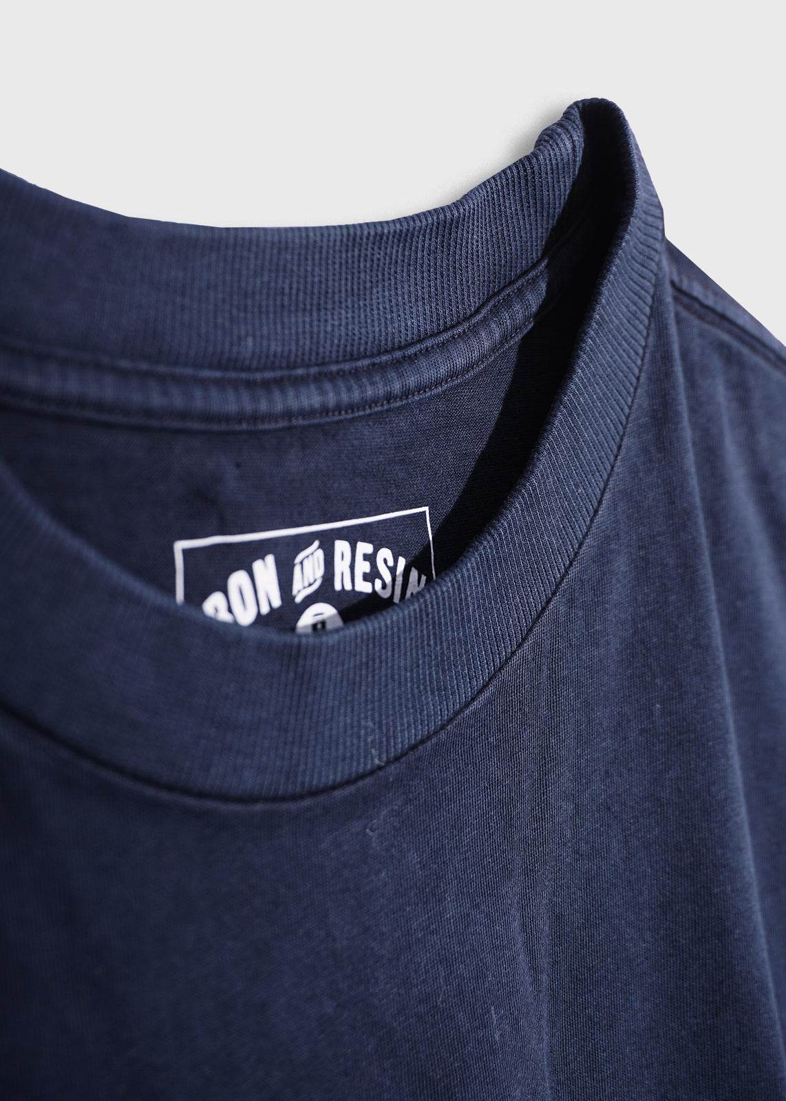Close-up shot of men’s 7.6 oz cotton, navy pocket tee, showing details of fabric 
