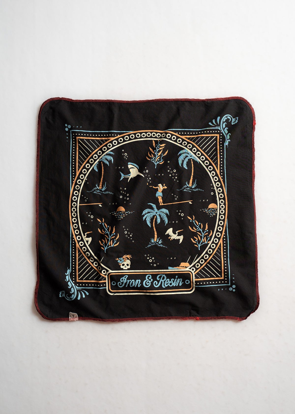 A black bandana with tropical and nautical motifs, featuring palm trees and sharks, branded with "Iron & Resin" in the center.