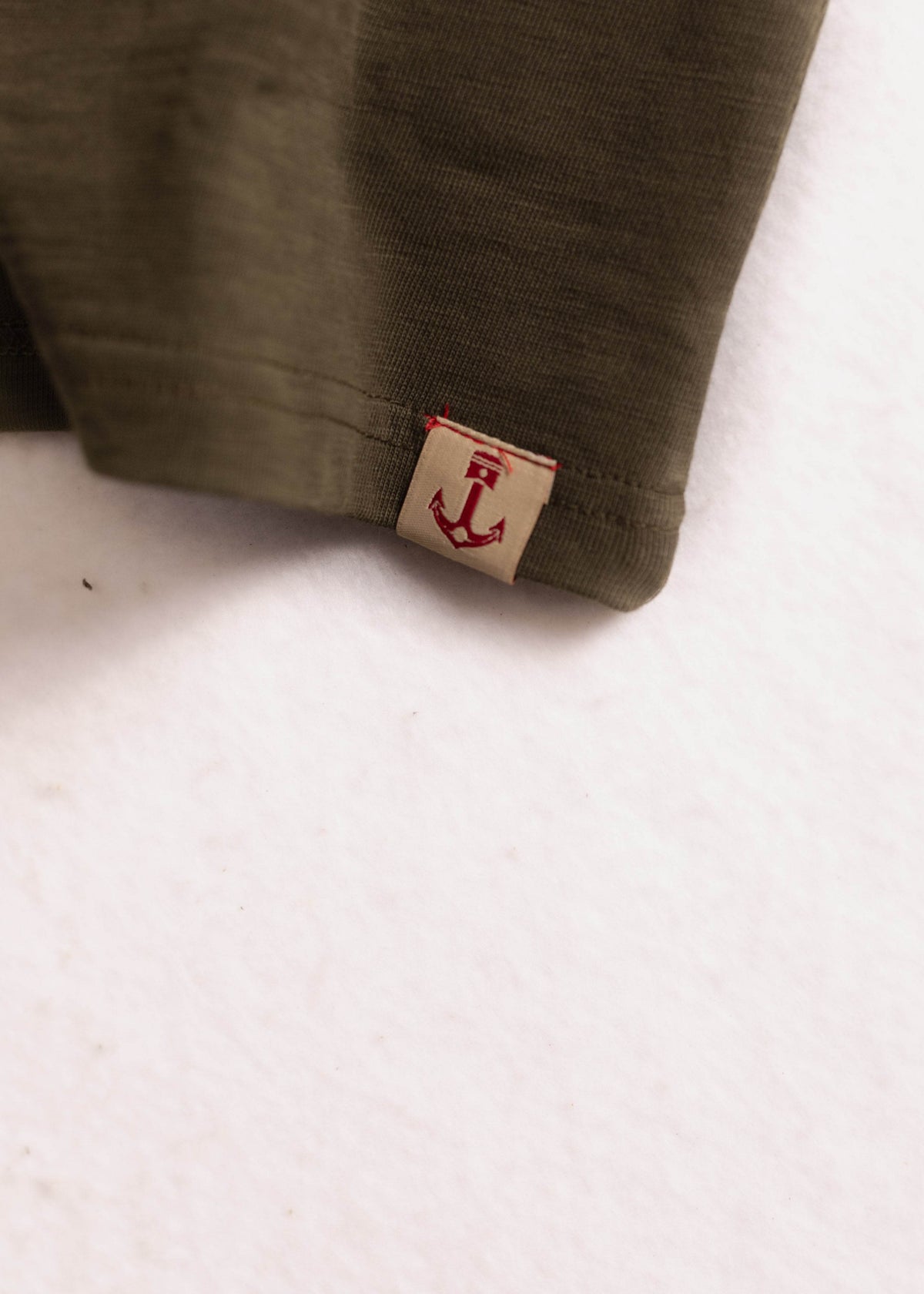 Close up of garment dyed cotton slub shirt detail and textured fabric with custom logo tag