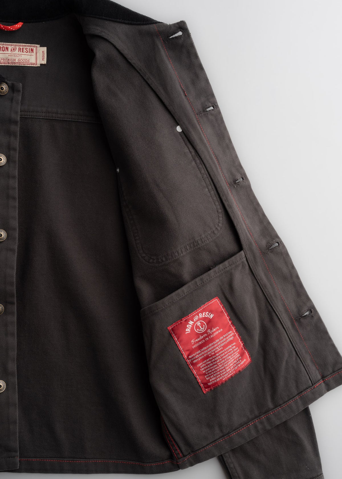 Close up of peach bull denim fabric showing interior, custom label, textured cotton weave and durable workwear construction