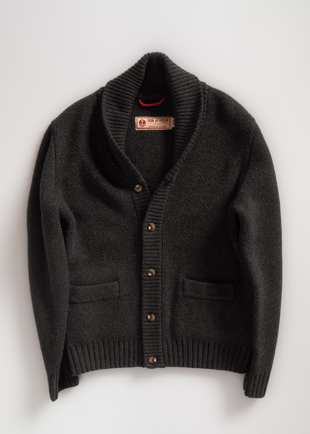 Dark shawl collar cardigan with buttons and pockets, labeled Iron & Resin, displayed on a white background. Cozy and stylish.