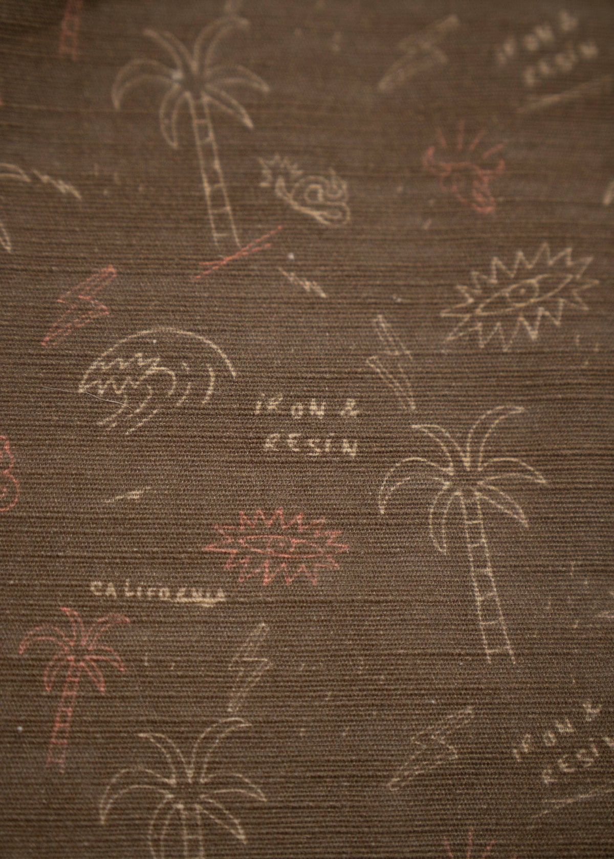 Brown fabric with palm trees, waves, and "Iron & Resin" text, evoking a California beach vibe. Subtle, artistic design.
