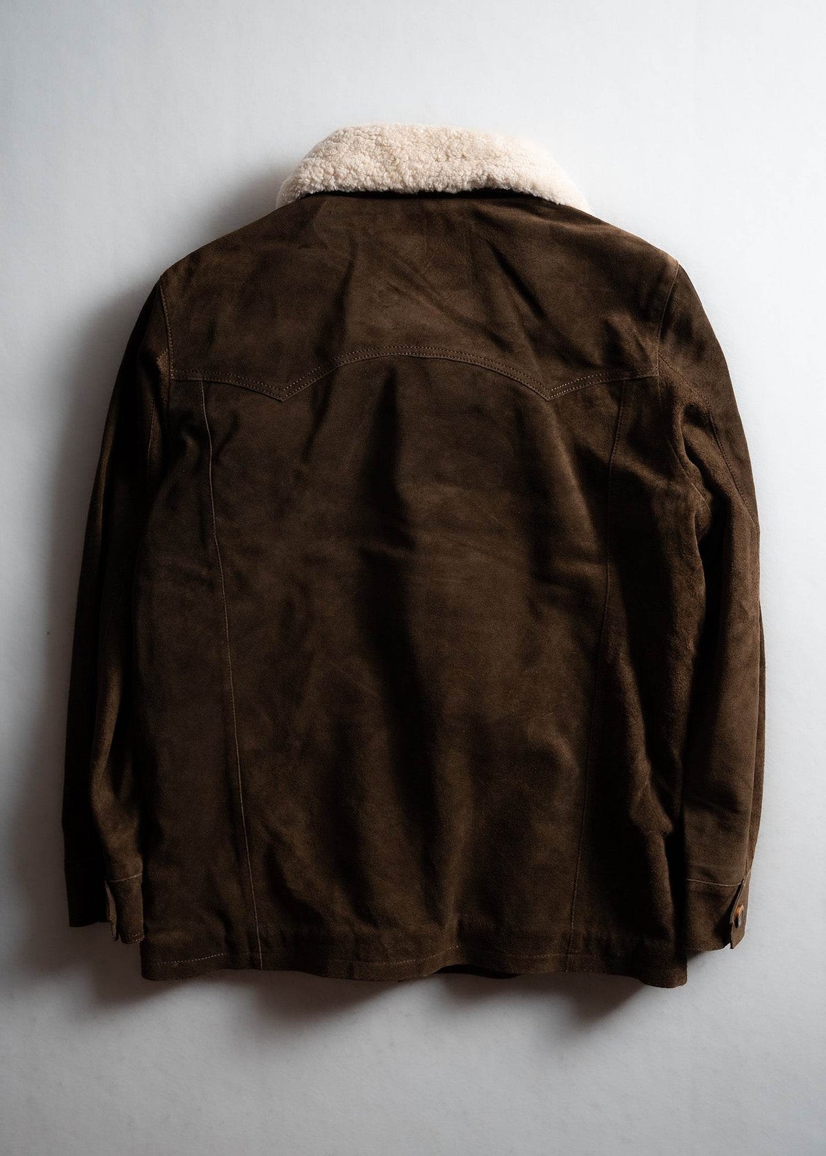 Brown suede jacket with a white shearling collar, displayed on a light background, showcasing its back design and texture.