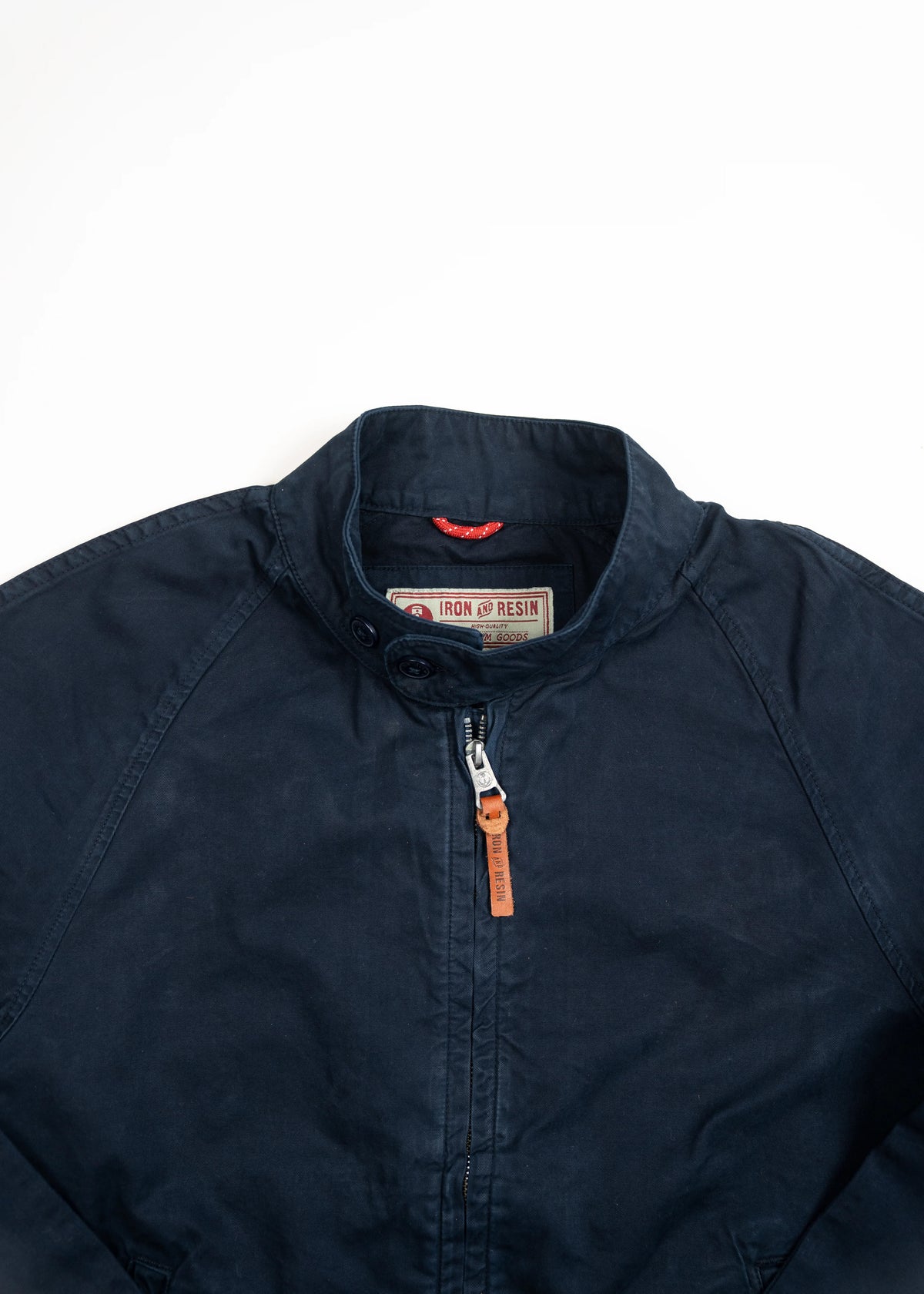 Navy blue Iron & Resin jacket with a high collar and leather zipper pull, displayed on a white background for a clean look.