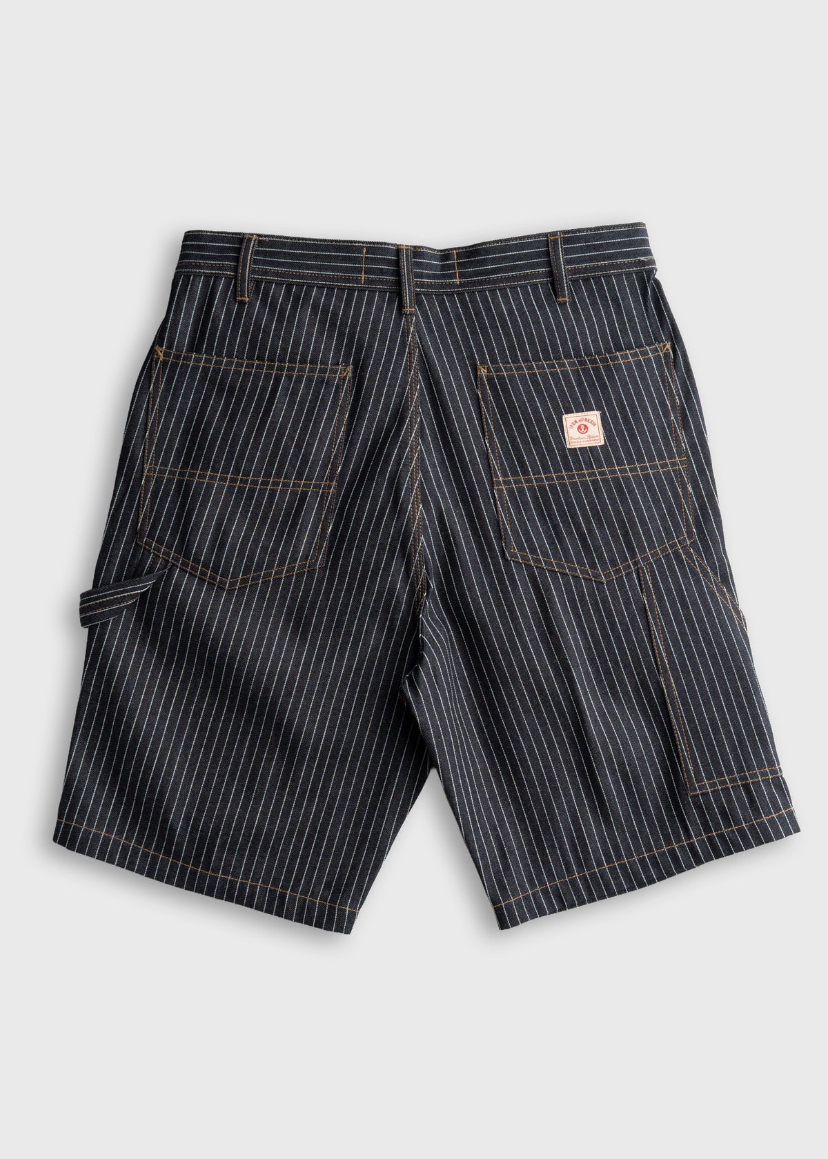 Pinstriped work shorts with back pockets and a small logo patch, displayed on a plain background, highlighting their design.