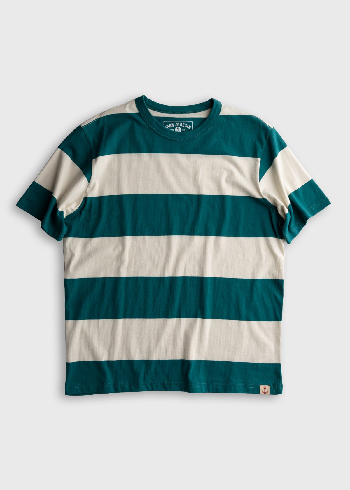 Teal and cream striped t-shirt with a round neck, displayed on a flat surface. A small anchor logo is visible at the bottom.