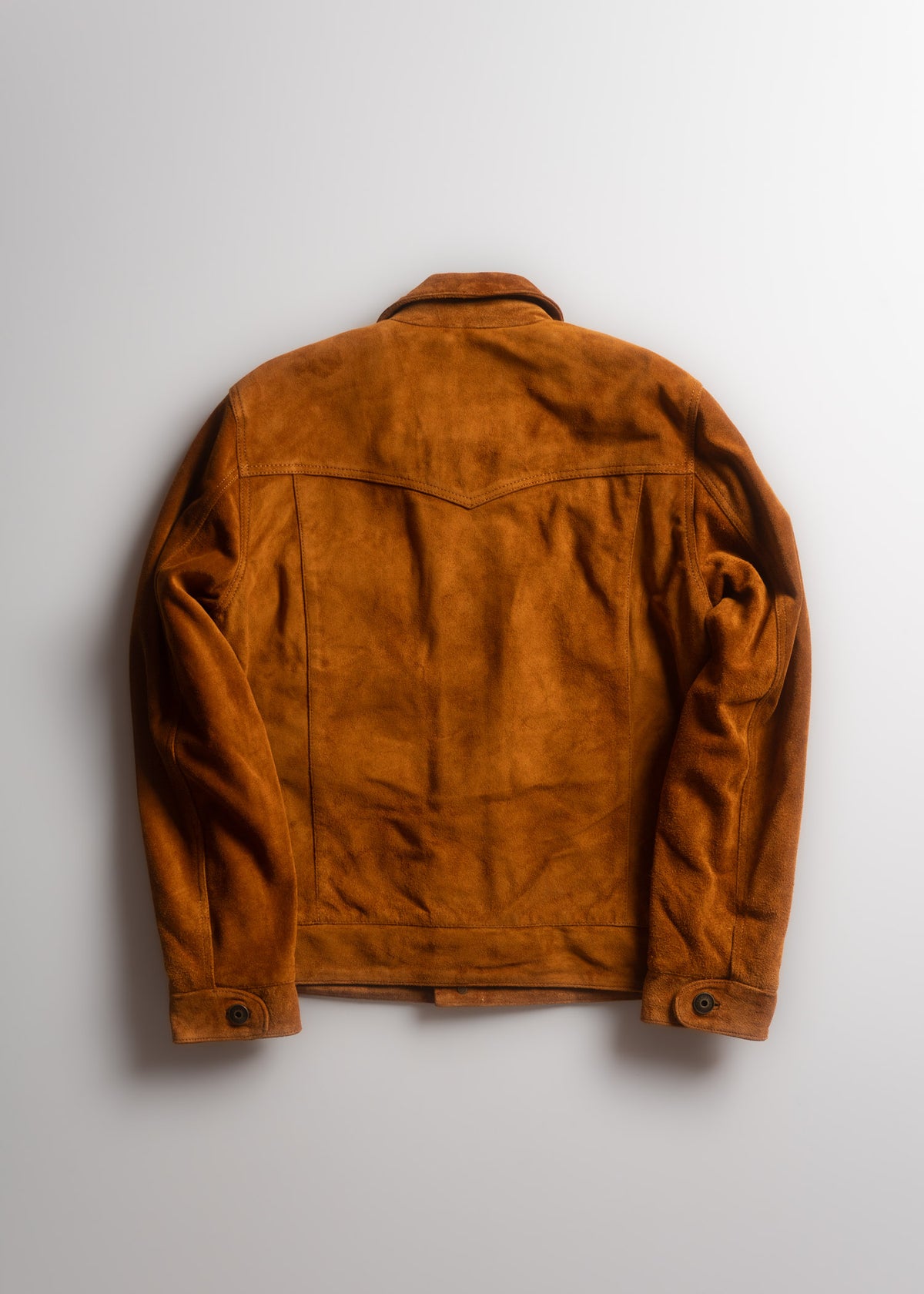 Brown suede jacket with buttoned cuffs, viewed from the back, against a light gray background. Classic and stylish design.