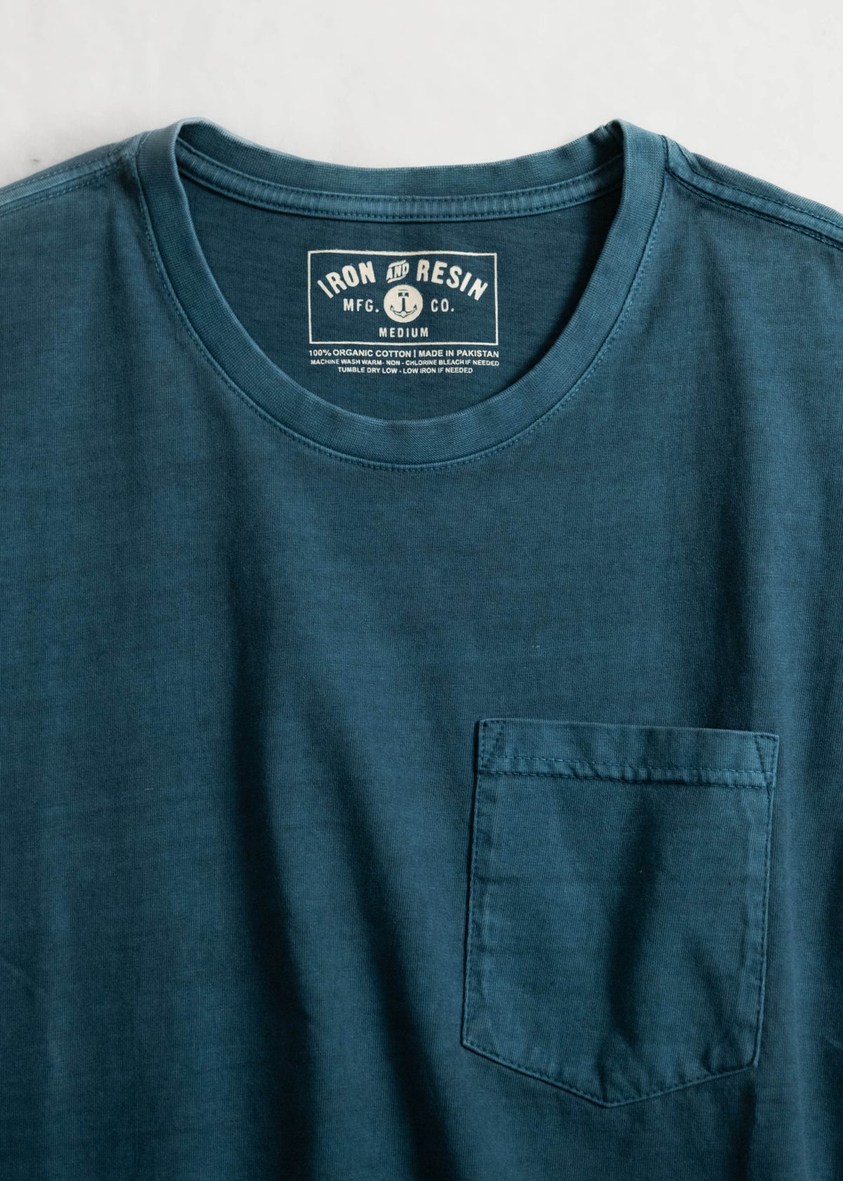Faded Pocket Tee showcasing detail of fabric chest pocket and screen printed label