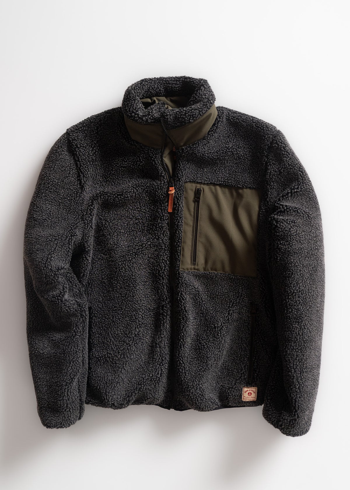 Dark fleece jacket with olive chest pocket and zipper, laid flat on a white background, showcasing its cozy texture and design.