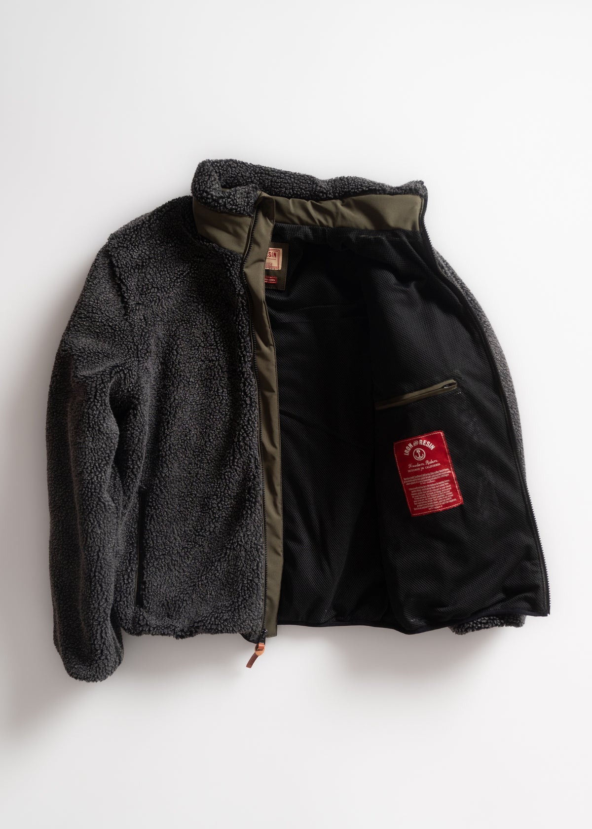Gray fleece jacket with olive lining, open to reveal a red label inside. The jacket is laid flat on a white background.