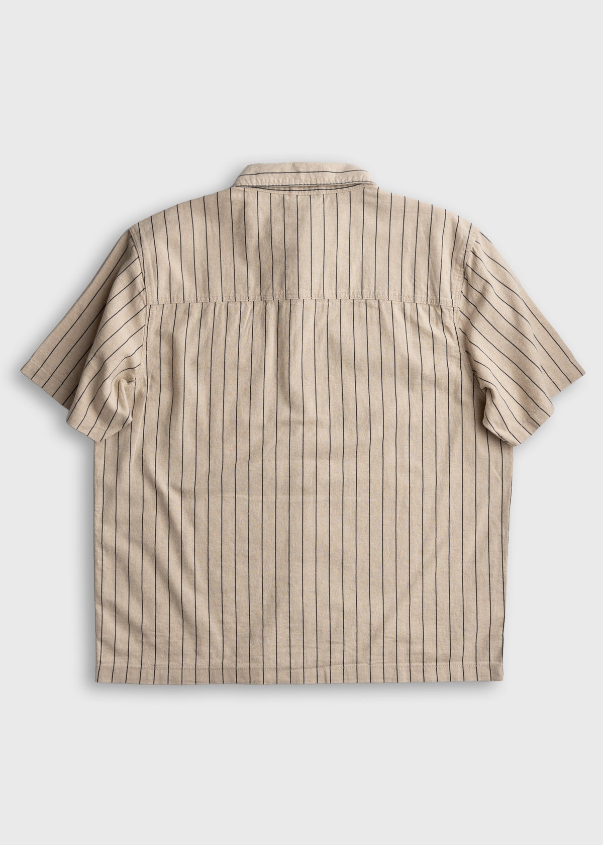 Beige short-sleeve shirt with vertical black stripes, viewed from the back on a plain background.