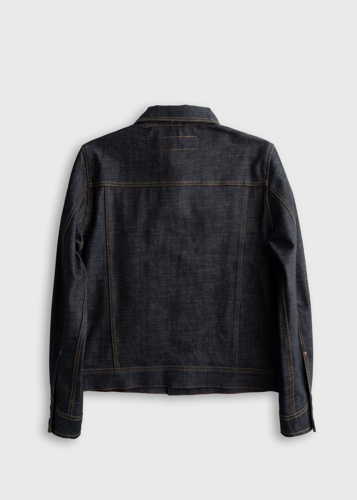 Dark denim jacket viewed from the back, showcasing classic stitching and structured design against a plain background.