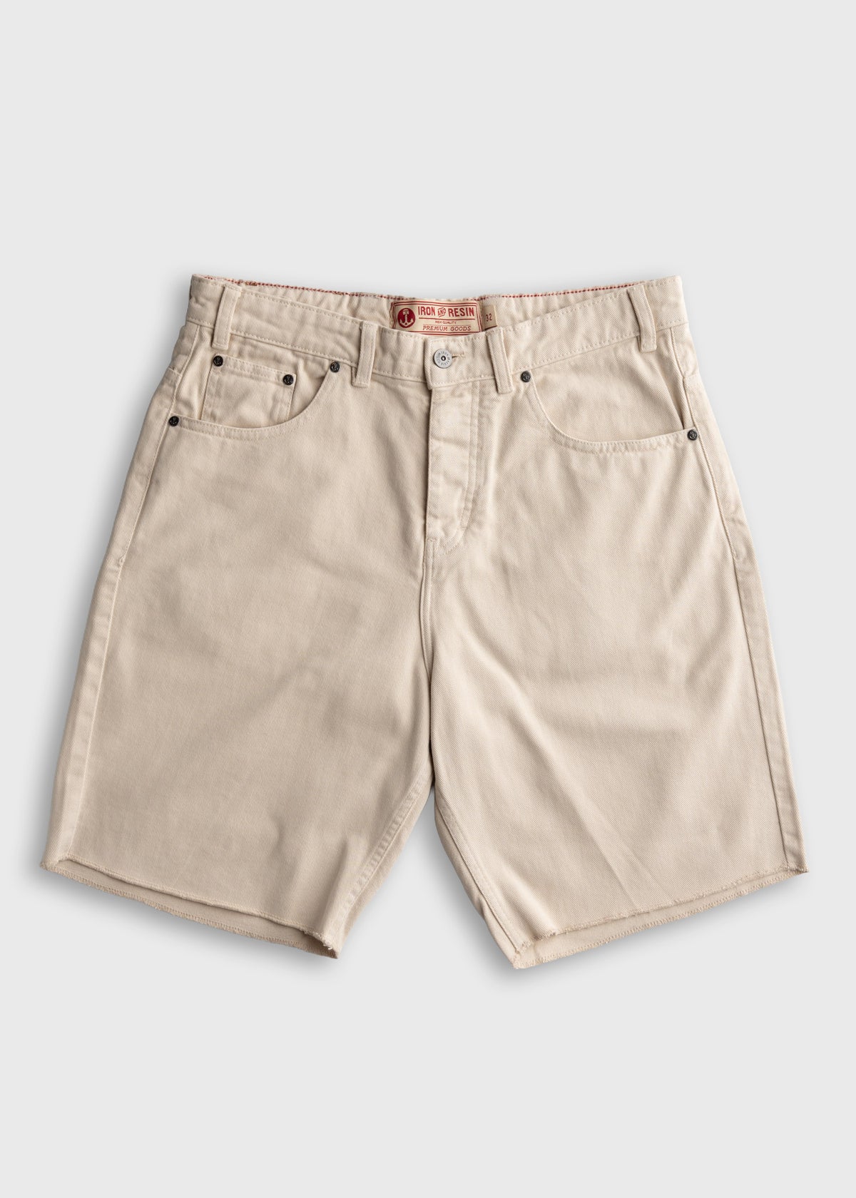 Beige cotton shorts with belt loops, five pockets, and a button closure, displayed on a plain background.