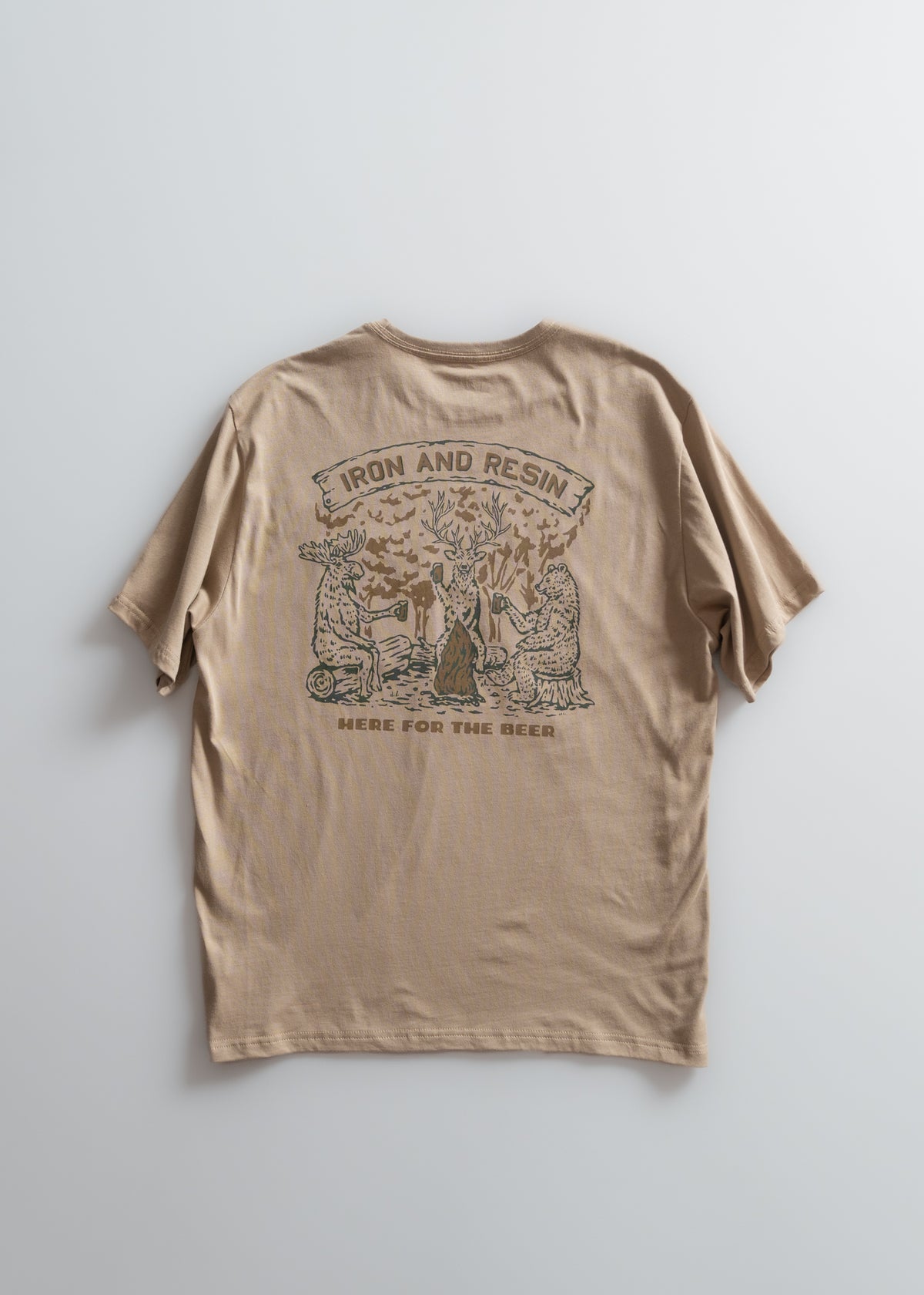Tan t-shirt with "Iron and Resin" and "Here for the Beer" text, featuring animals around a tree.