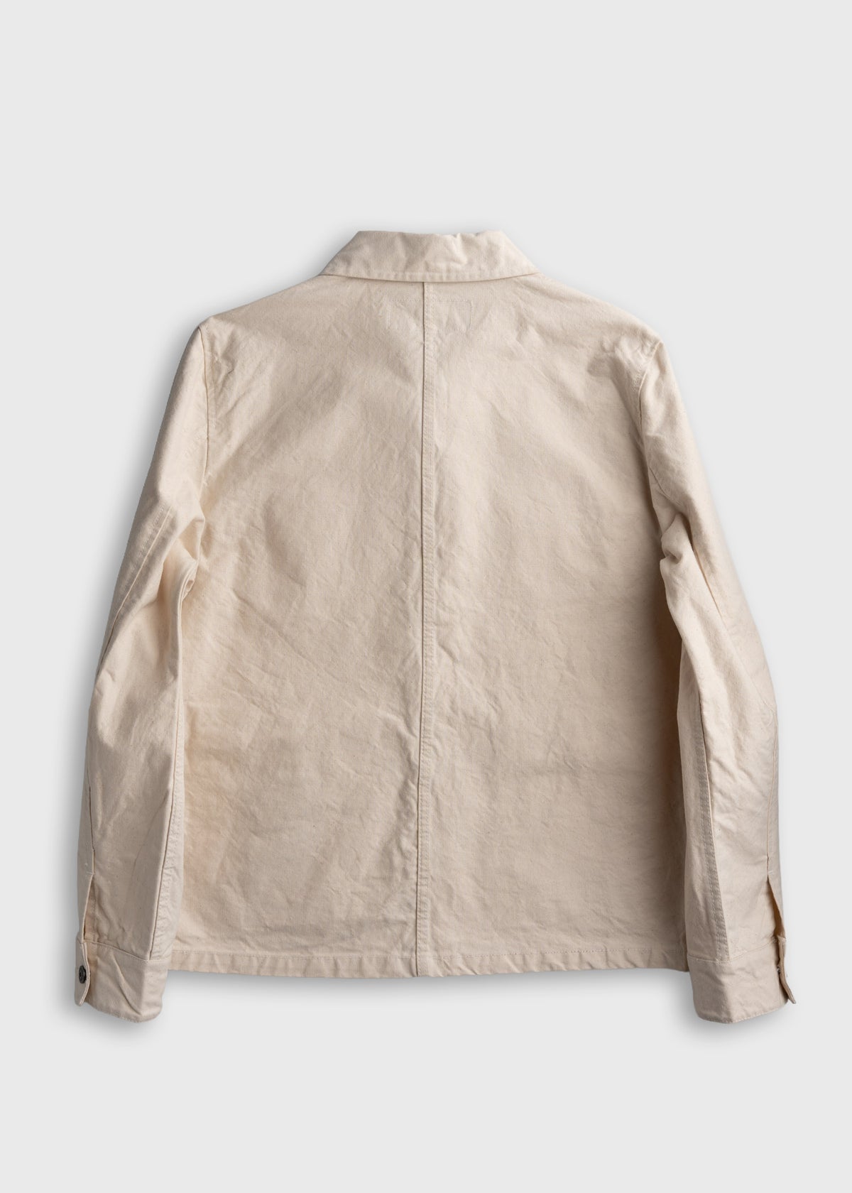 Beige jacket back view on white background, showing collar, long sleeves, and buttoned cuffs. Simple, casual style.