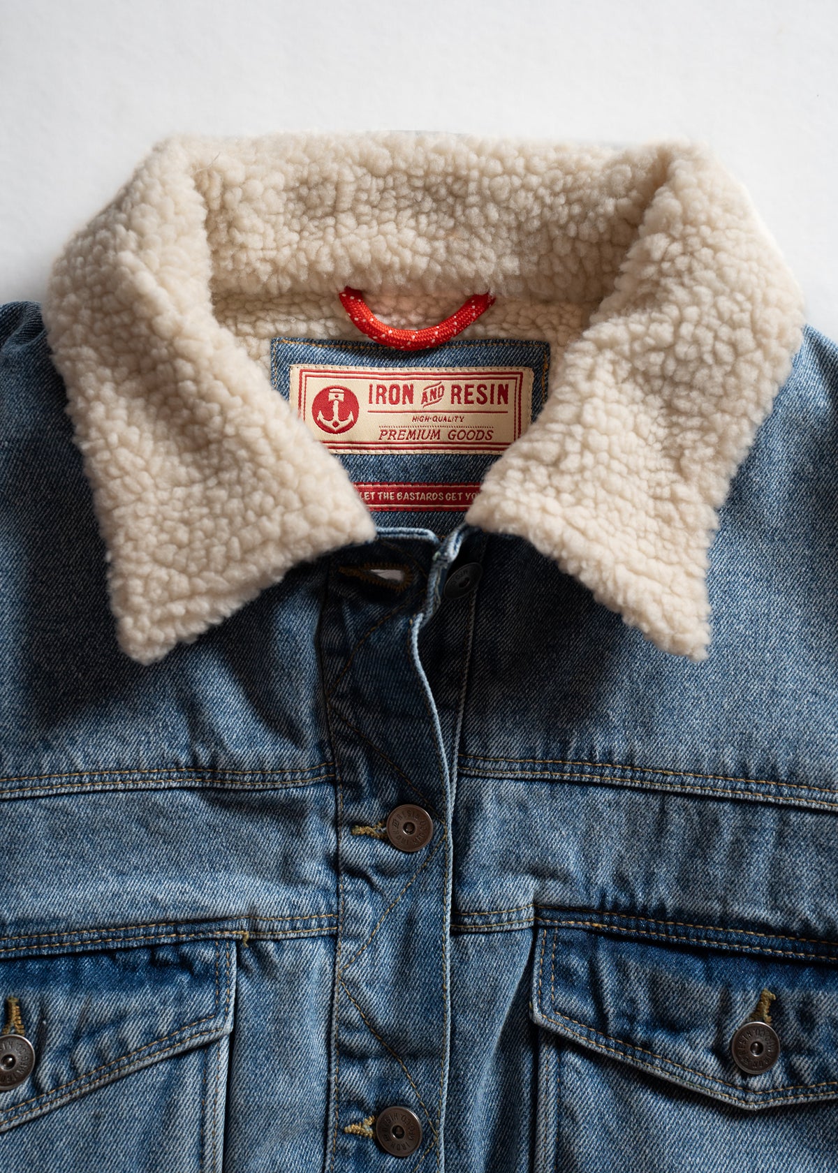 Denim jacket with a sherpa collar and Iron and Resin label, showcasing premium quality and rugged style.