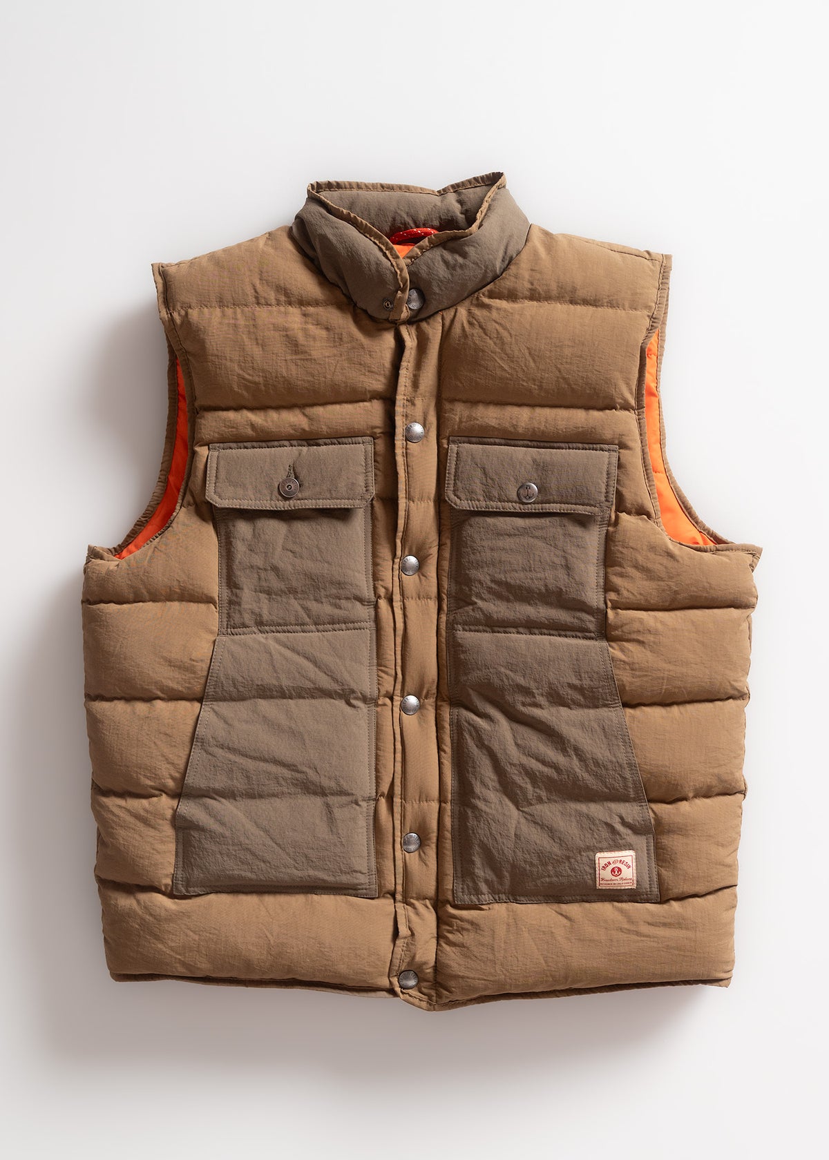 Brown puffer vest with snap buttons, two front pockets, and orange lining, displayed against a white background.