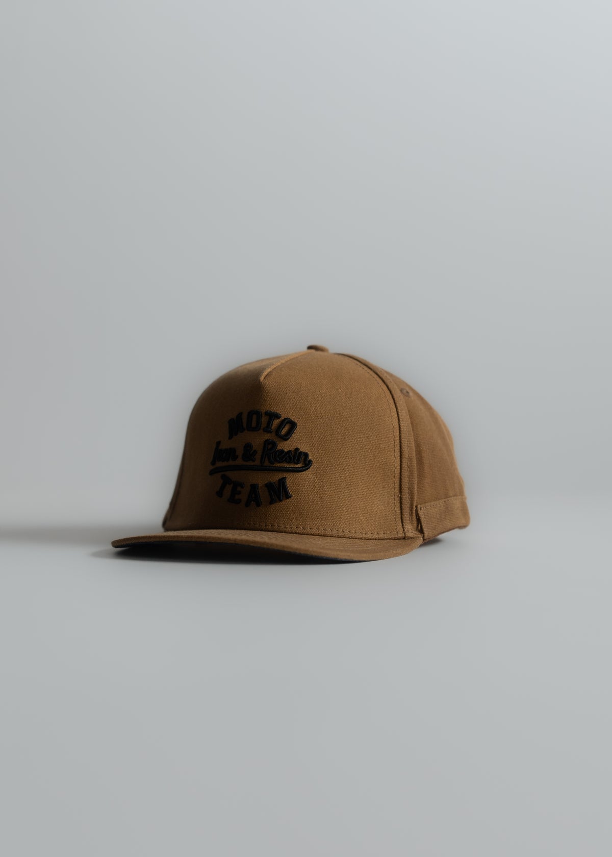 Brown cap with "Moto Team" text, displayed on a plain background, showcasing a casual and sporty style.
