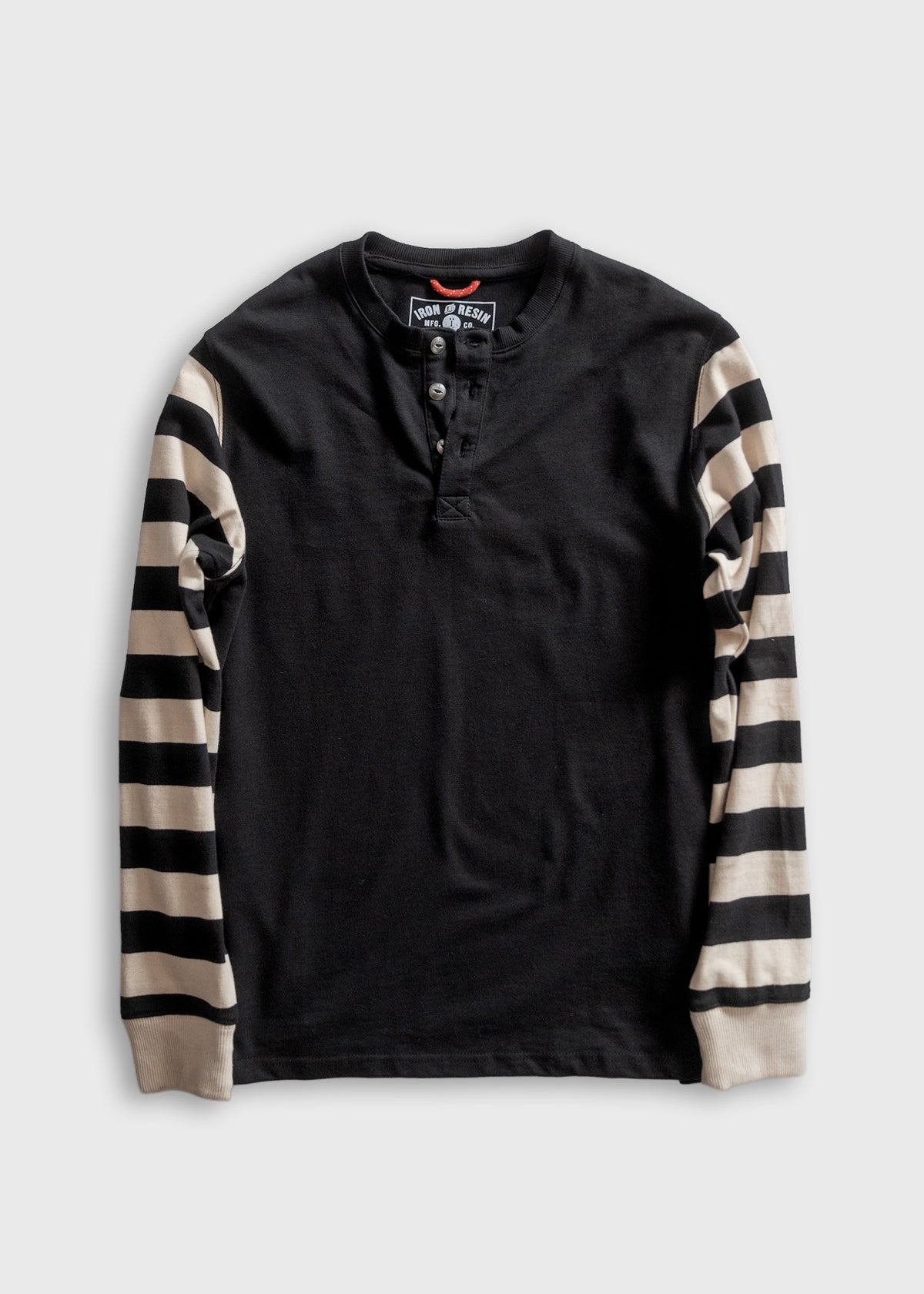Black henley shirt with striped sleeves on a white background, featuring buttons and a visible brand label at the collar.