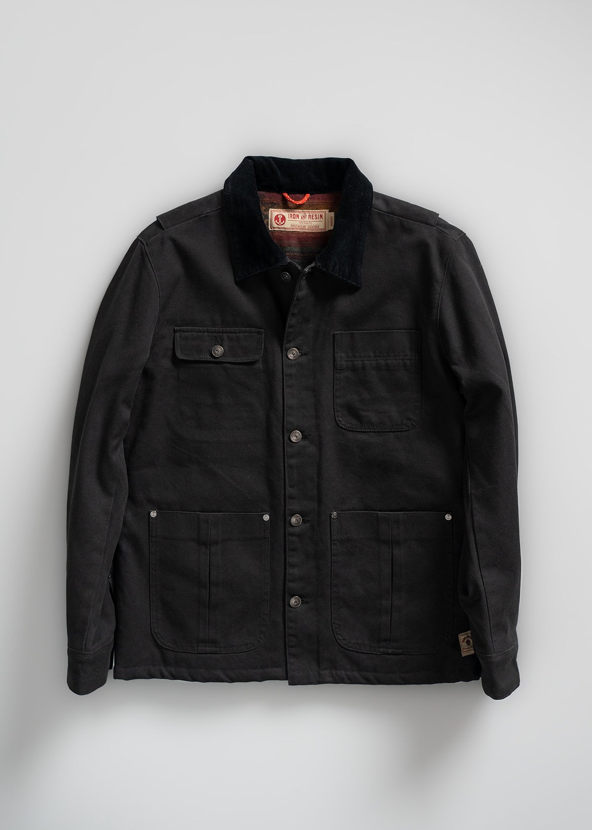Black canvas jacket with button front, four pockets, and a corduroy collar, displayed on a plain white background.