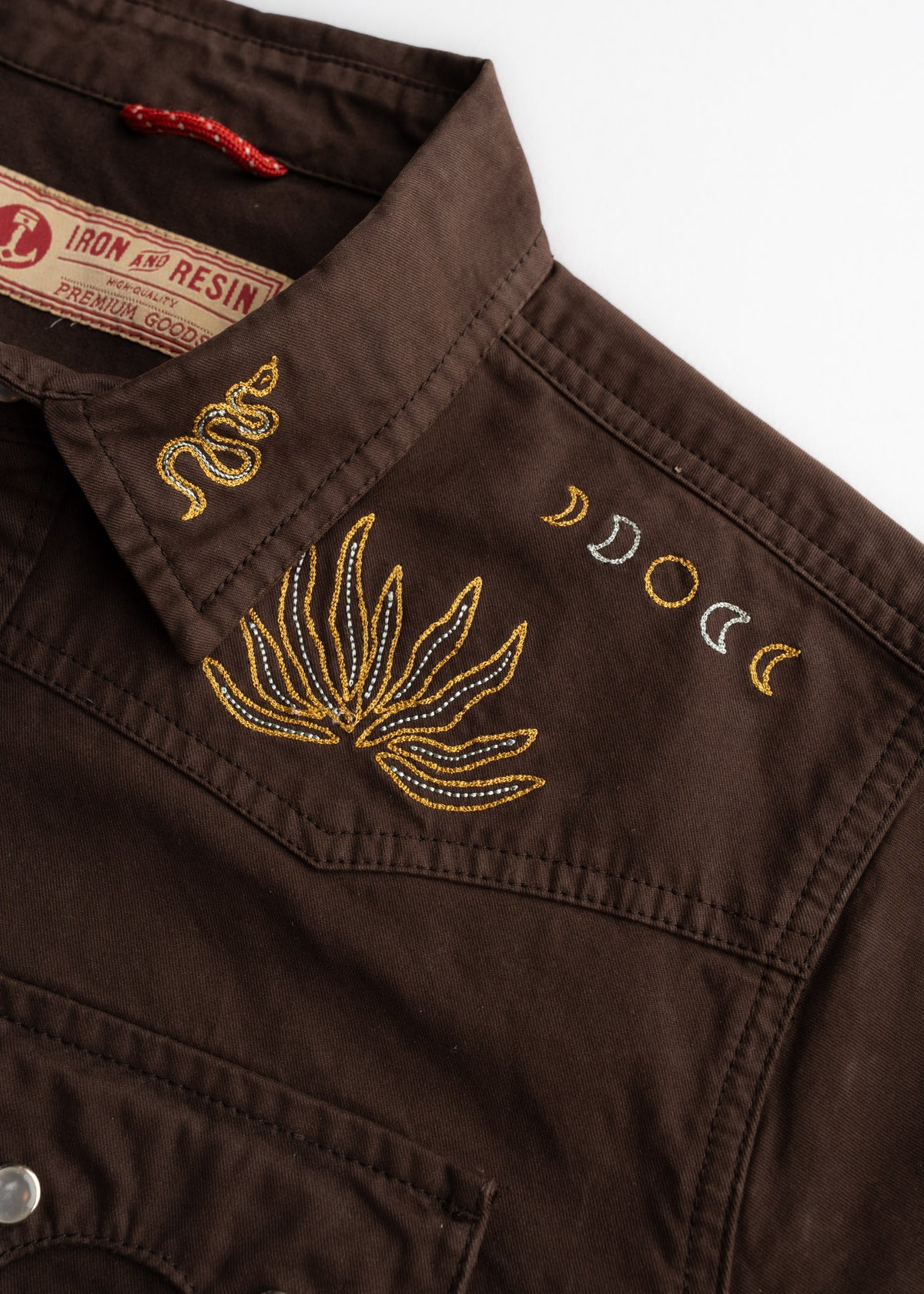 Close up of Prescott twill shirt with pearl snap closure, highlighting custom embroidery, and stitching
