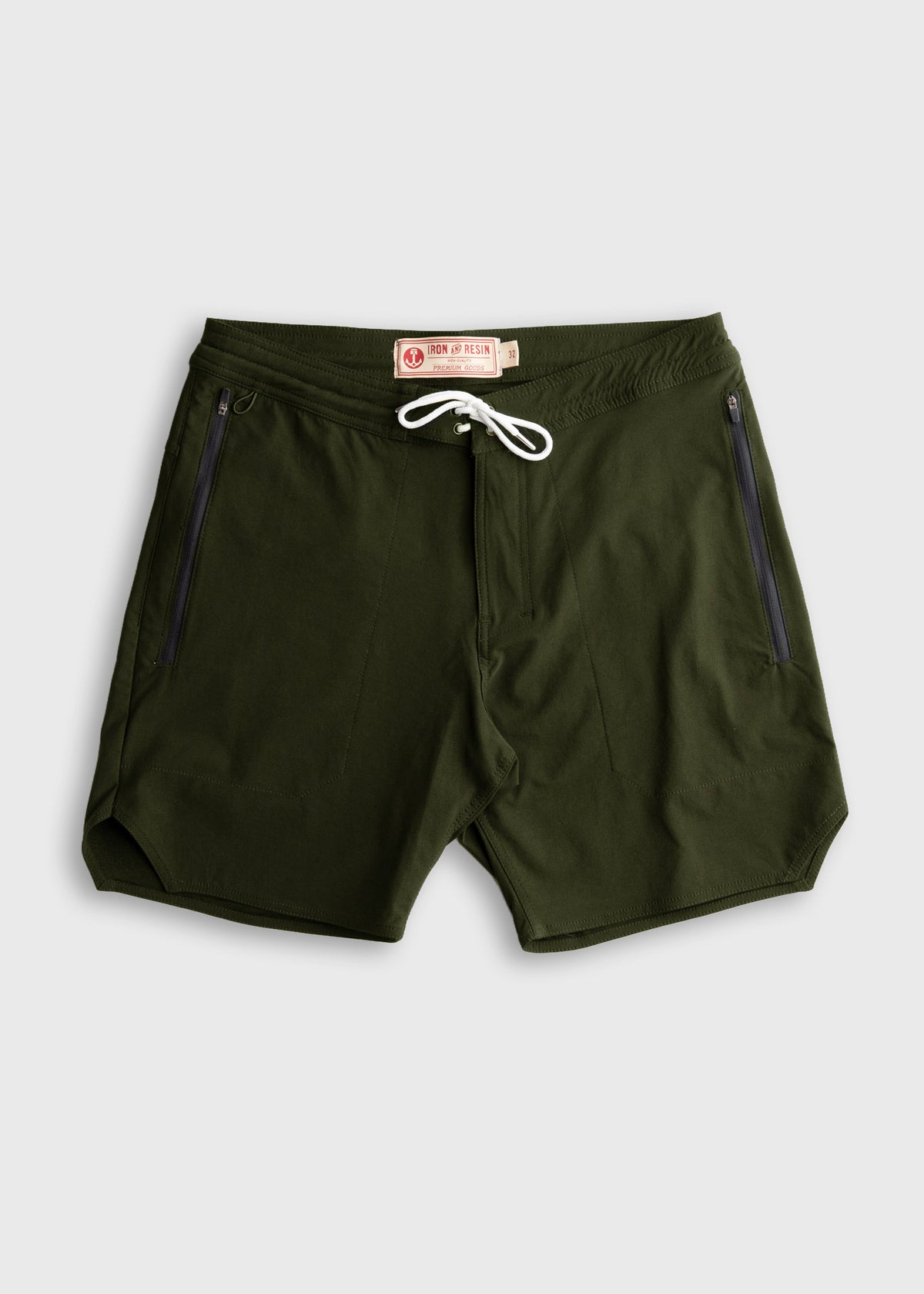 Green shorts with white drawstring and zippered pockets, labeled "Iron & Resin," displayed on a plain gray background.