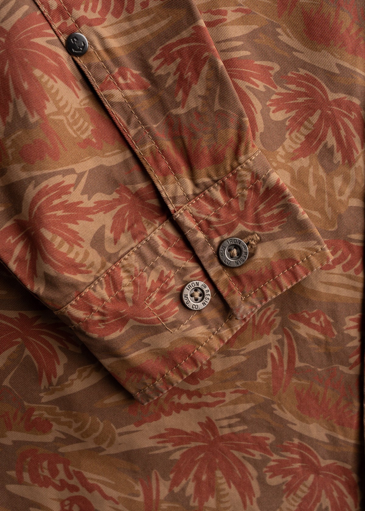 Close up of metal buttons on shirt, highlighting front closure and hardware detail