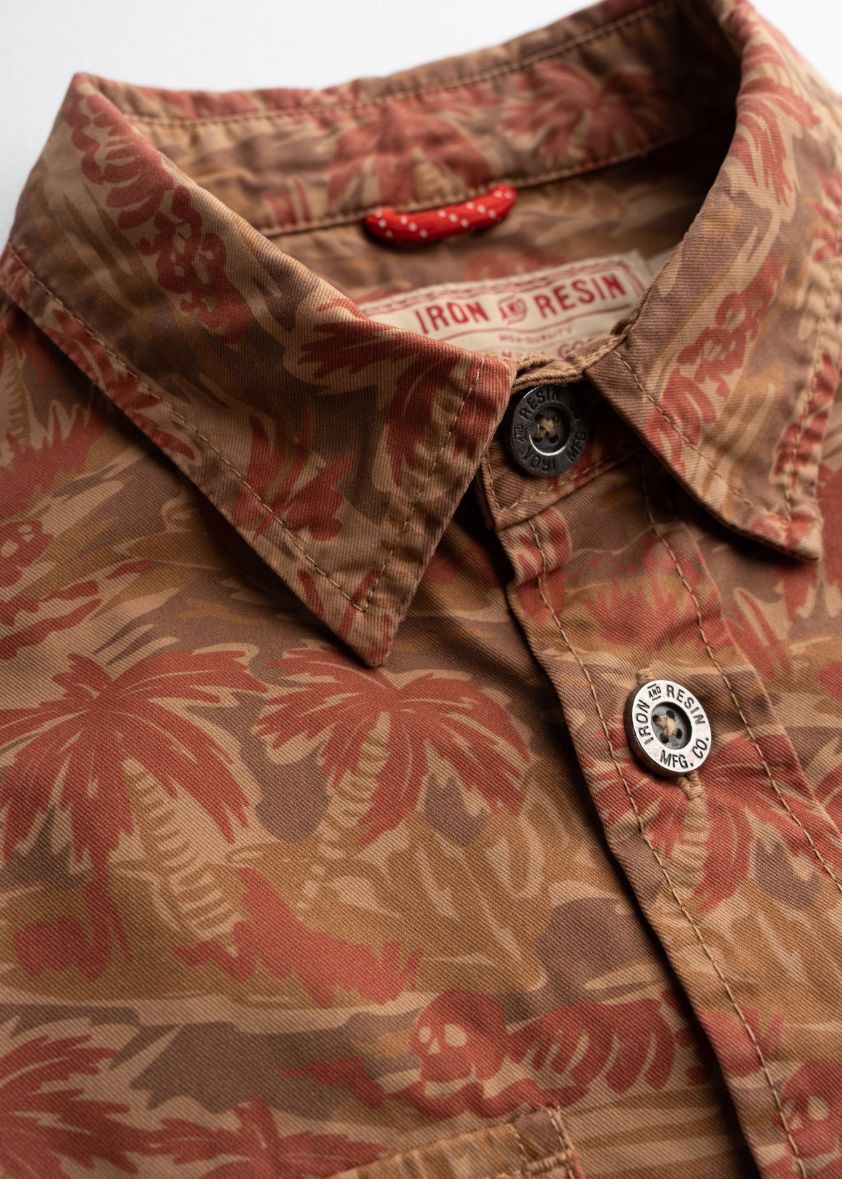 Close up of woven neck label and interior locker loop, highlighting custom buttons,  and practical workwear detailing
