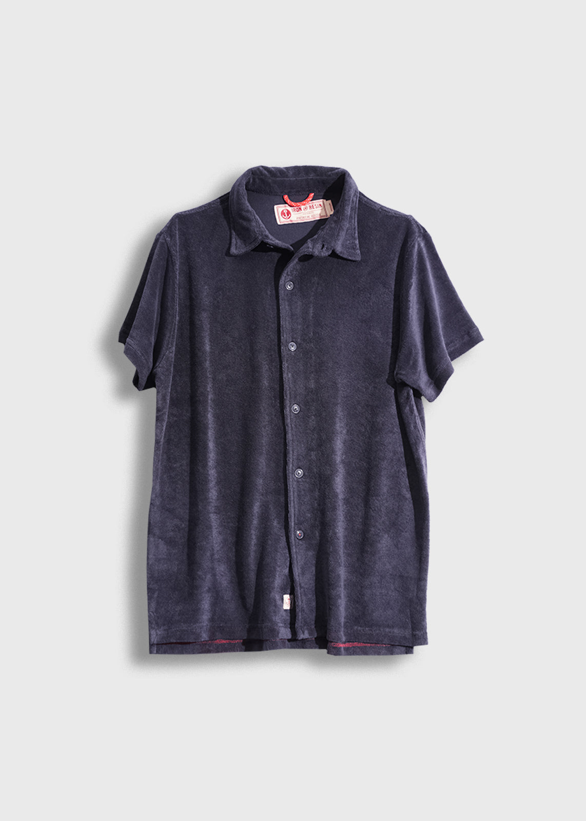 Dark blue short-sleeve button-up shirt with a collar, displayed on a light background, featuring a visible red label inside.