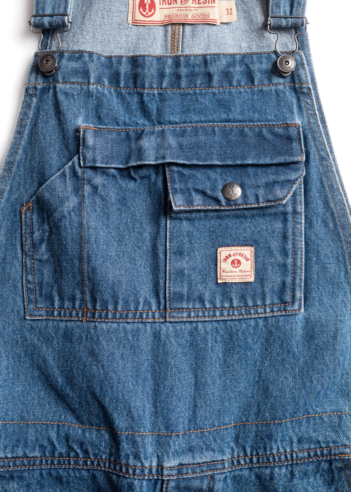Denim overalls with a front pocket, button detail, and Iron & Resin label, showcasing rugged, high-quality craftsmanship.