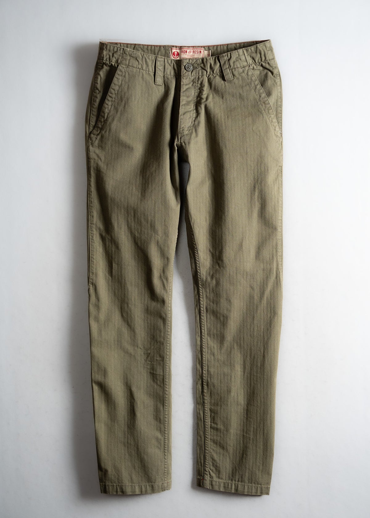 Olive green pants with a button closure and side pockets, displayed flat on a light background, showcasing casual style.