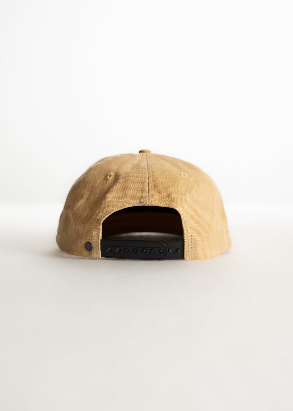 Tan baseball cap with adjustable black strap, viewed from the back, on a plain white background.
