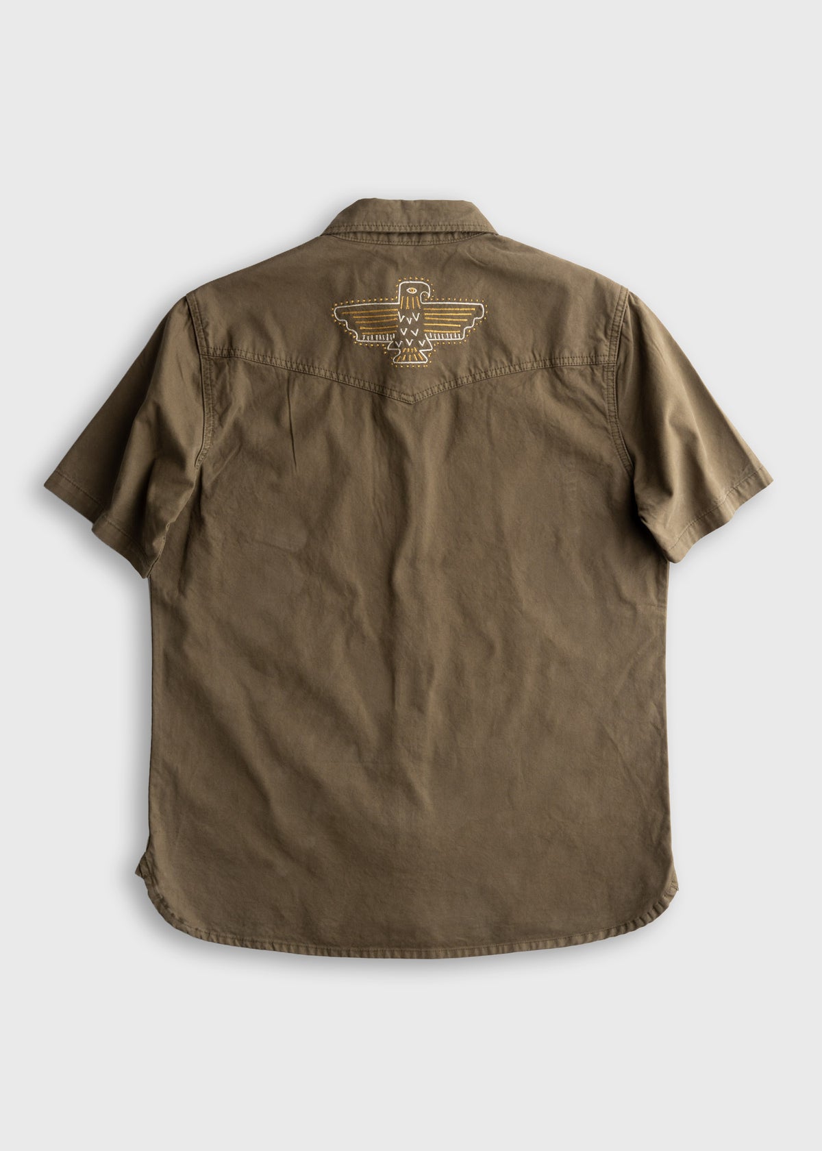 Brown short-sleeve shirt with embroidered eagle design on the back, displayed on a plain background.