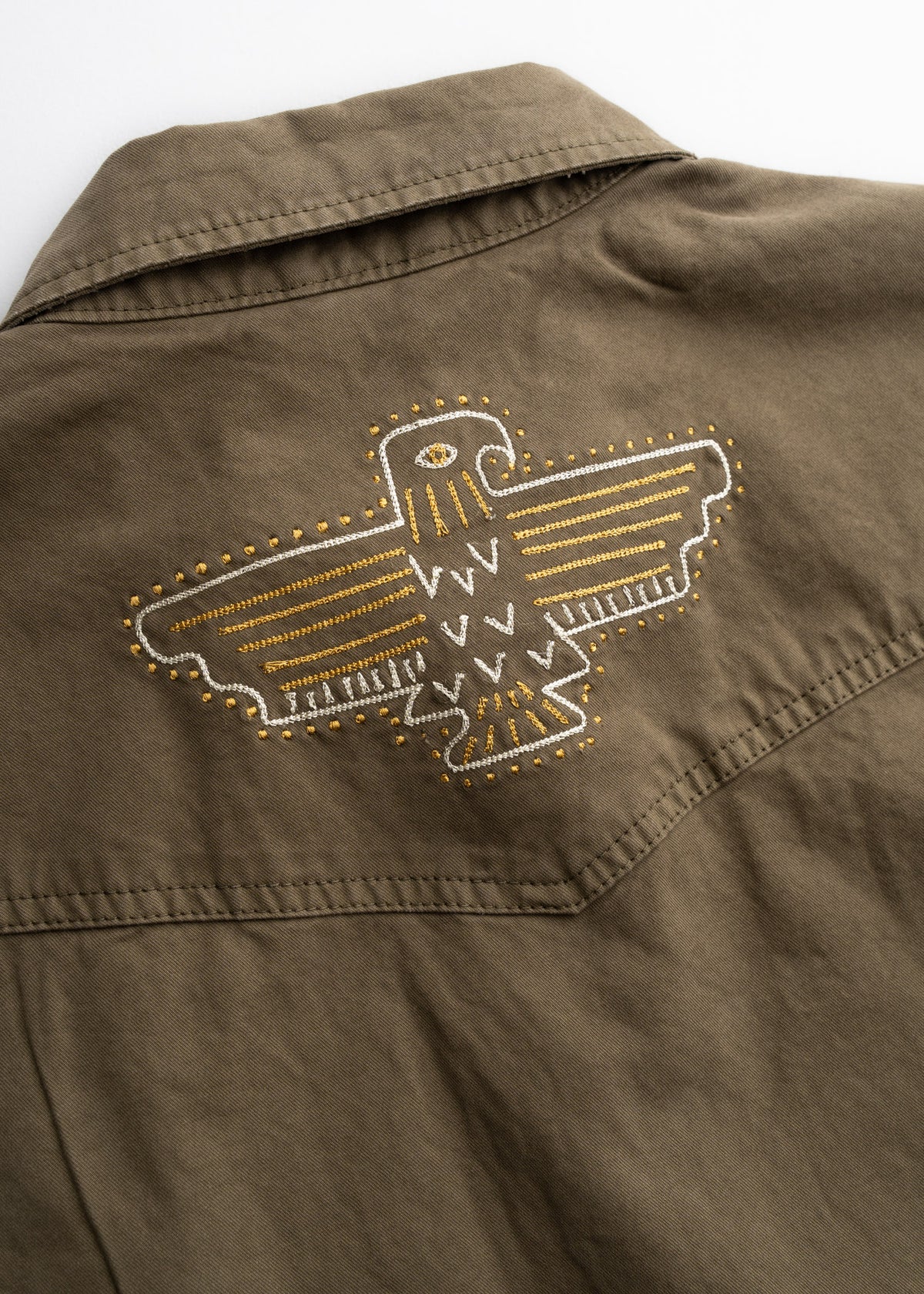 Close up of western style yoke and custom embroidery on button up shirt, highlighting back panel construction and classic detailing