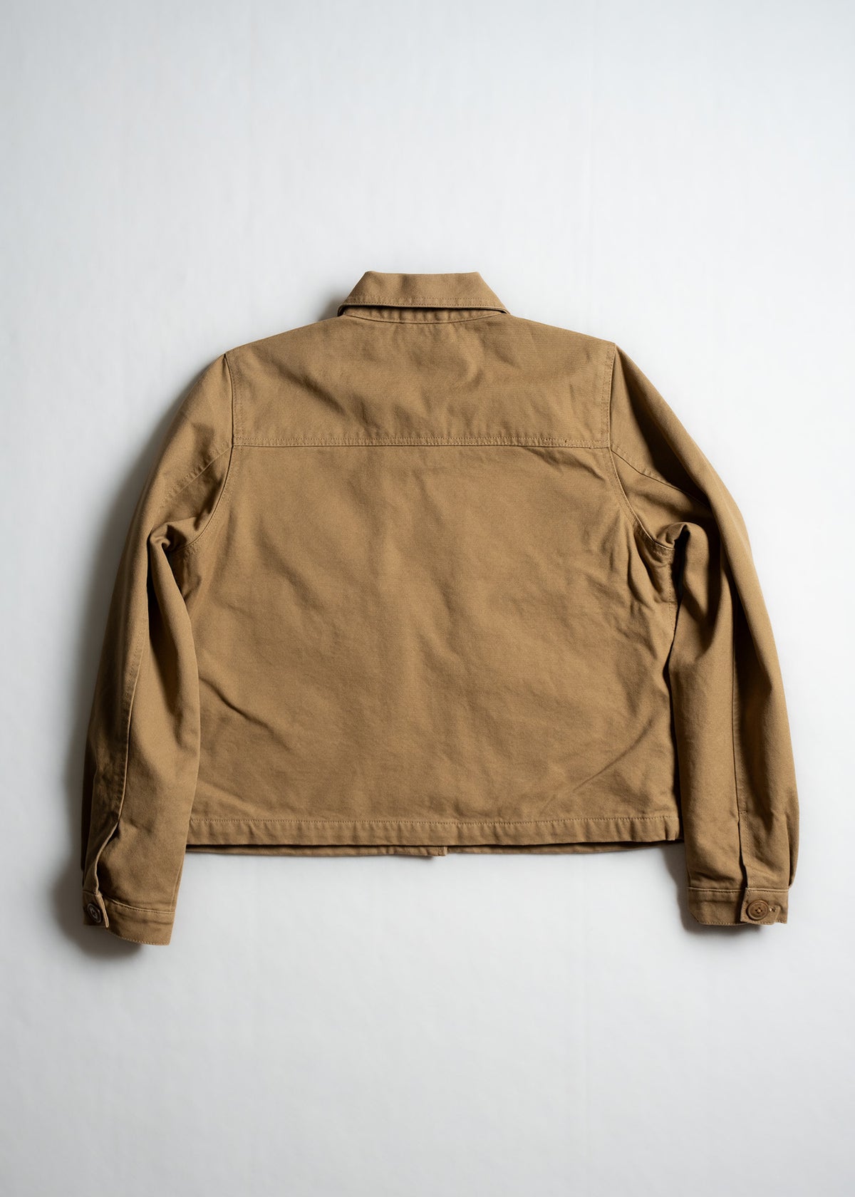 Tan jacket displayed on a white background, showcasing its back design with long sleeves and a classic collar.