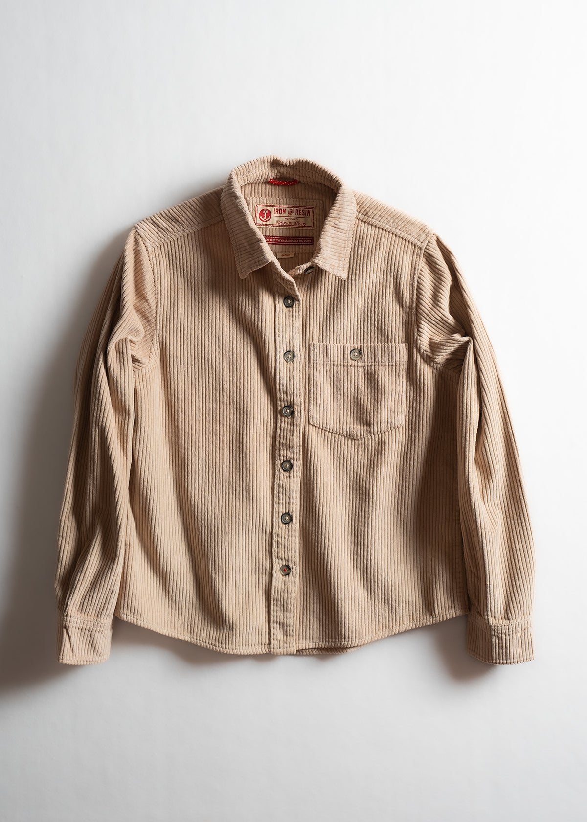 Tan corduroy button-up shirt with a chest pocket, displayed on a white background, showcasing its texture and design.